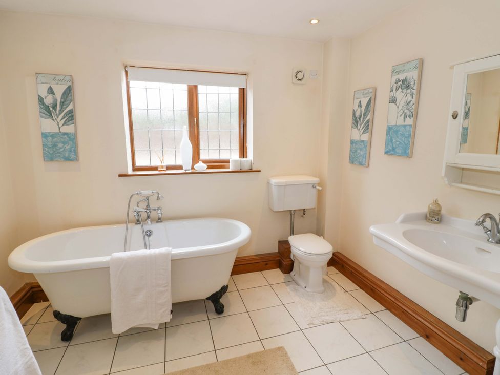 A bathroom with a bathtub, sink, and toilet at Meadow View Bungalow in Droitwich