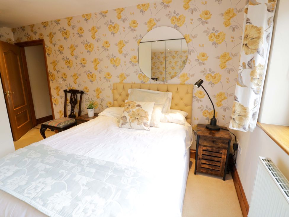 A bedroom with a bed and chair at Meadow View Bungalow in Droitwich