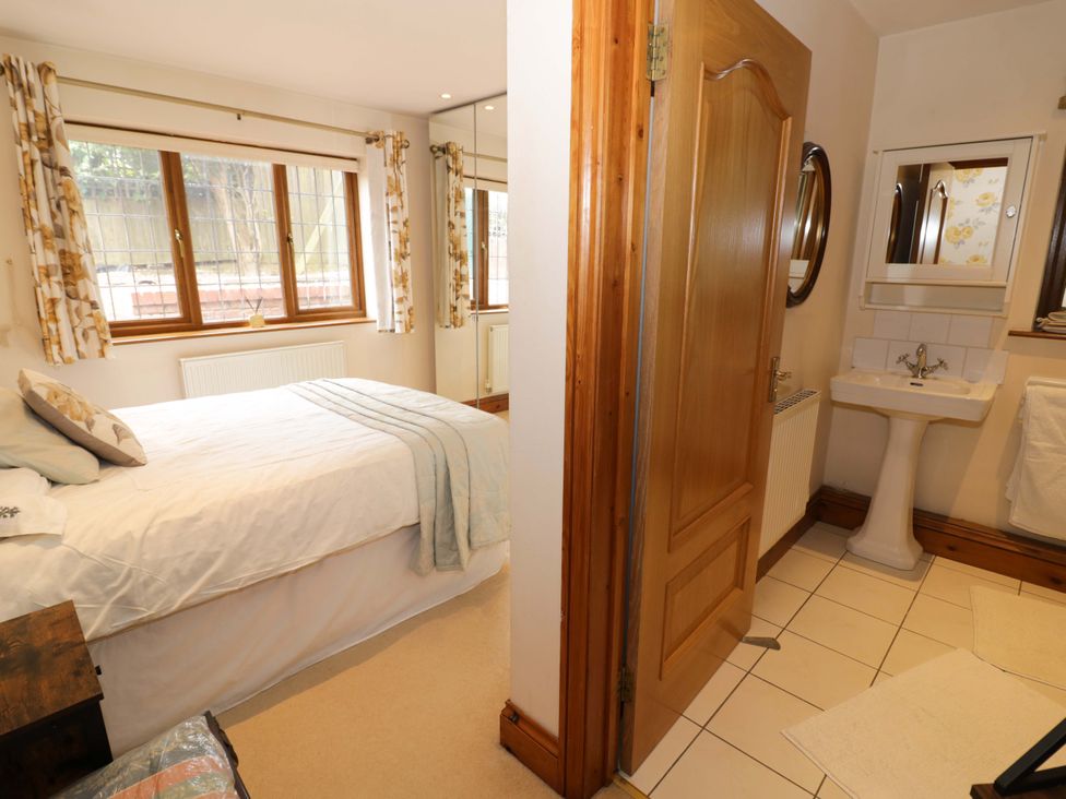 A bedroom with a bed and a sink at Meadow View Bungalow in Droitwich