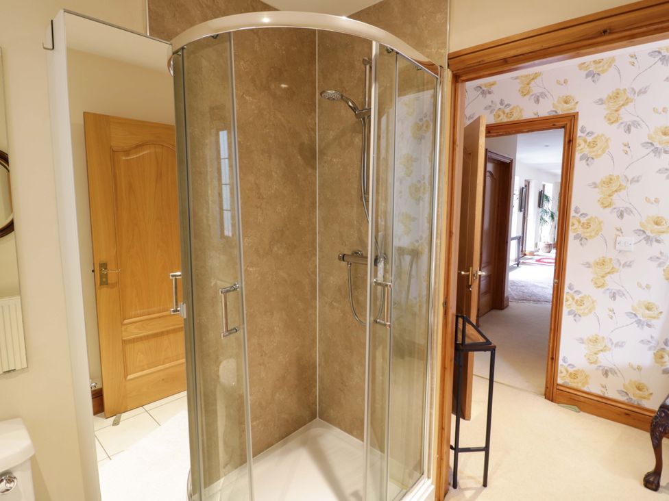 A shower cubicle with glass doors in a bathroom at Meadow View Bungalow Droitwich