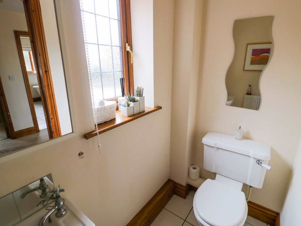 A bathroom with a toilet and sink at Meadow View Bungalow in Droitwich