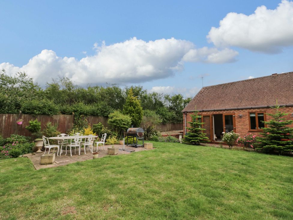 A garden with seating area and grill at Meadow View Bungalow in Droitwich