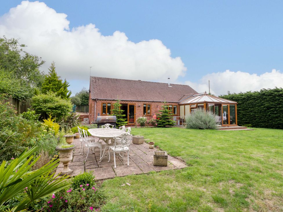 A garden with a bungalow and patio at Meadow View Bungalow in Droitwich