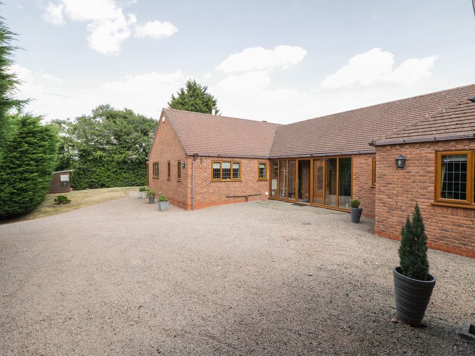 An exterior view of a garden with a gravel driveway at Meadow View Bungalow in Droitwich Spa