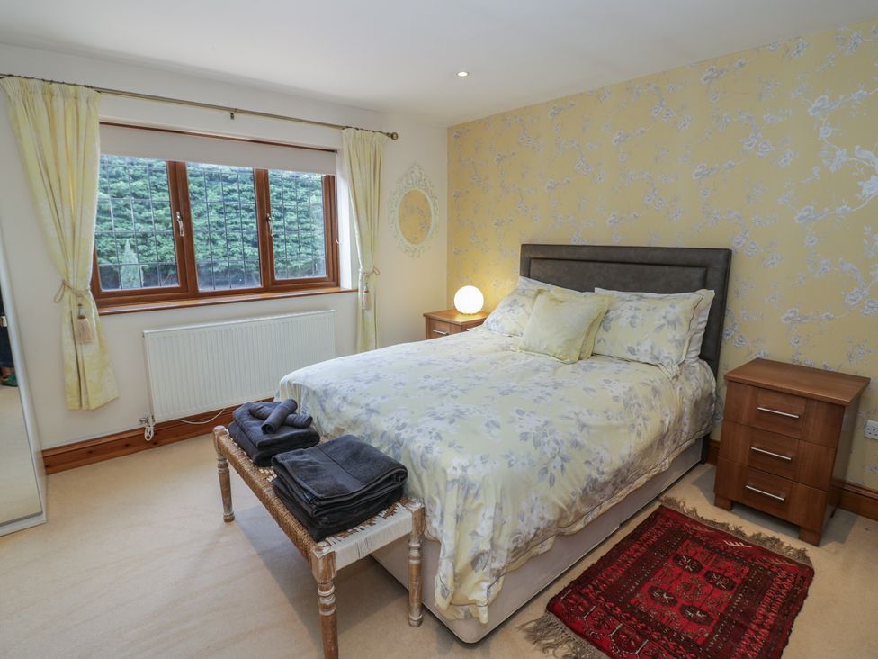 A bedroom with a bed and bedside table at Meadow View Bungalow in Droitwich Spa