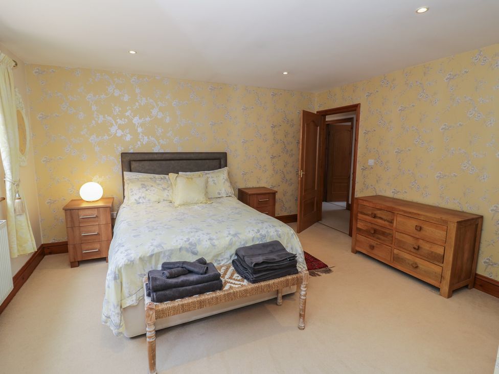 A bedroom with a bed and wooden furniture at Meadow View Bungalow in Droitwich Spa