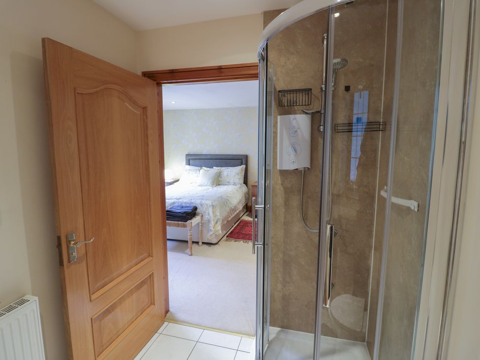 A bathroom with a shower and a door leading to a bedroom at Meadow View Bungalow in Droitwich Spa