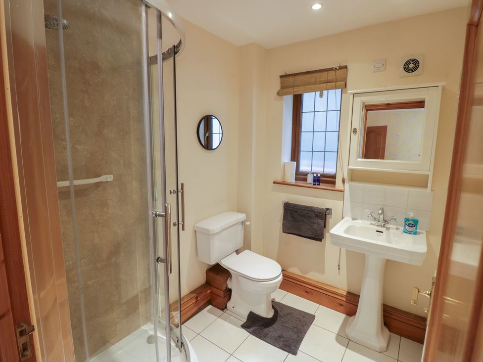 A bathroom with a shower, toilet, and sink at Meadow View Bungalow in Droitwich Spa