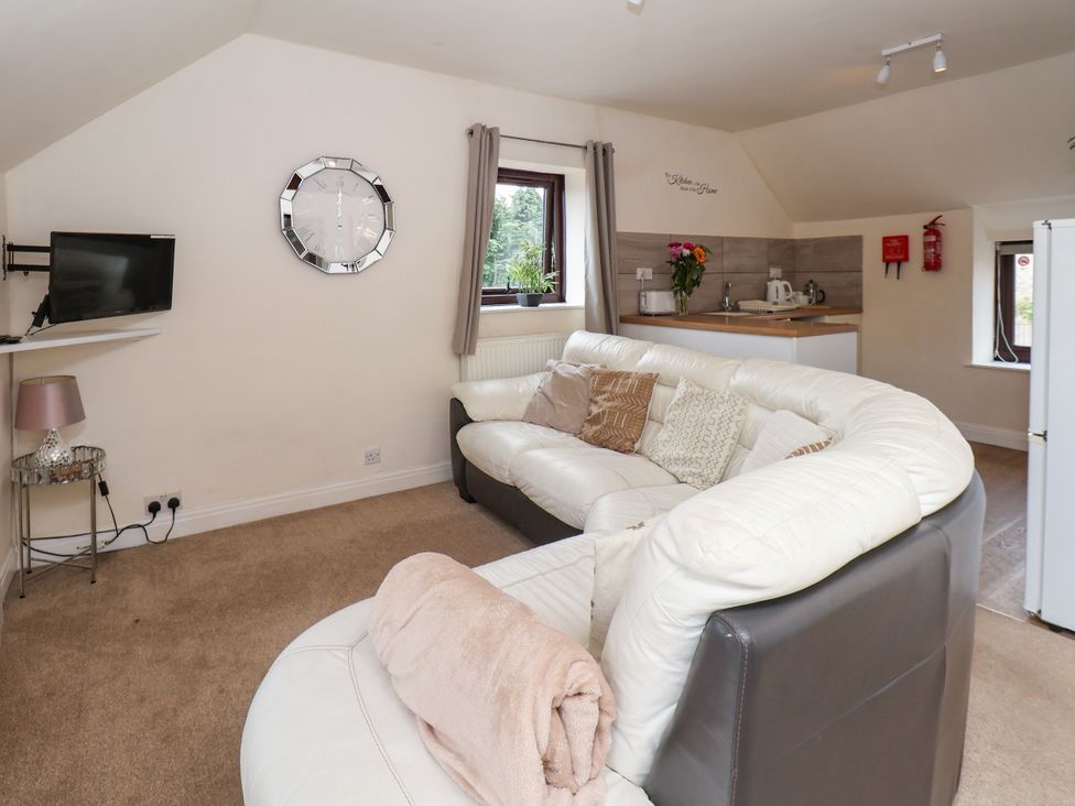 A living room with a sofa and television at Granary in peterculter