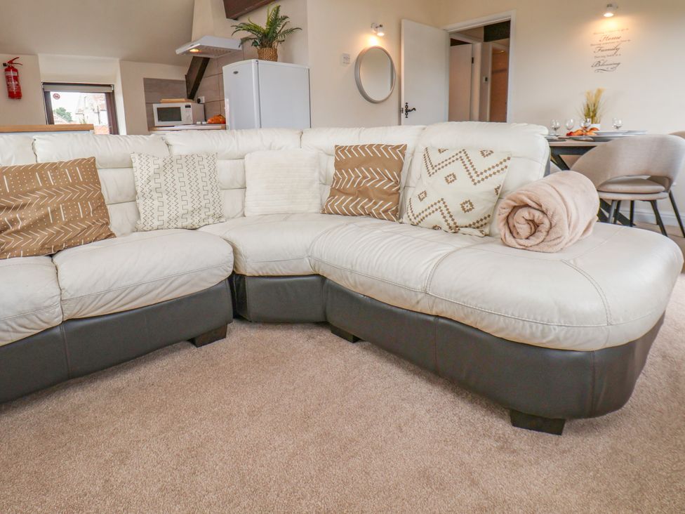 A living room with a sofa and cushions at Granary in peterculter