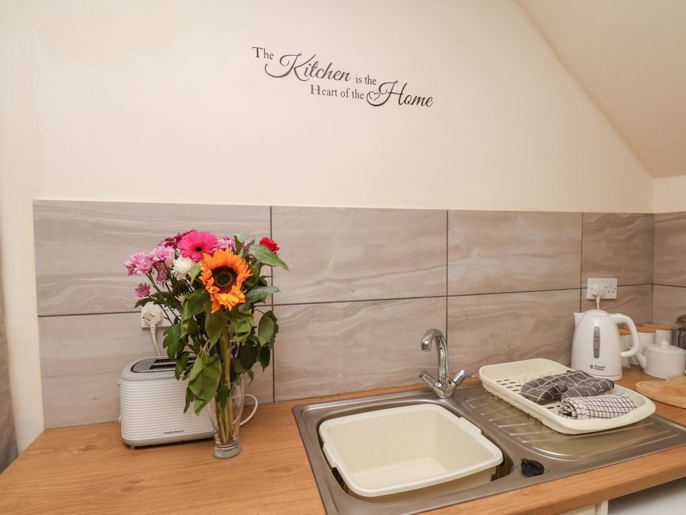 A kitchen with a sink, toaster, and flower vase at Granary in peterculter