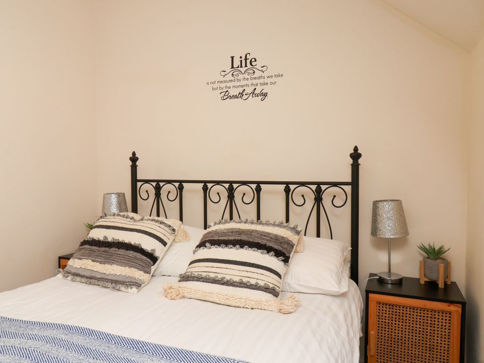 A bedroom with a bed and decorative pillows at Granary in peterculter