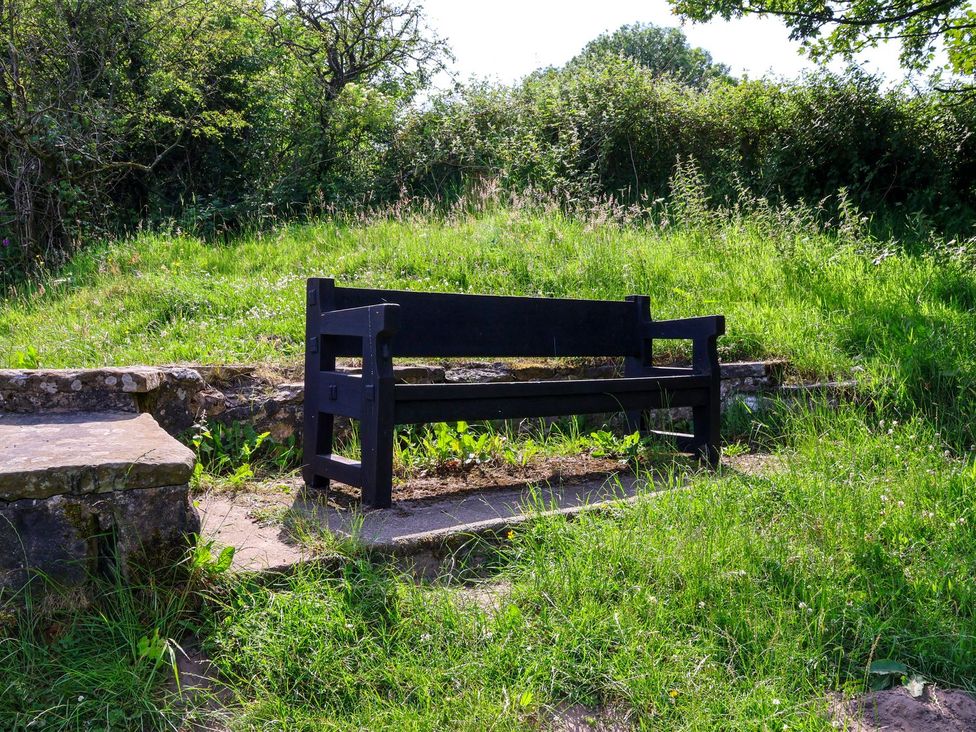 A black bench on grass near stone steps at Granary in peterculter