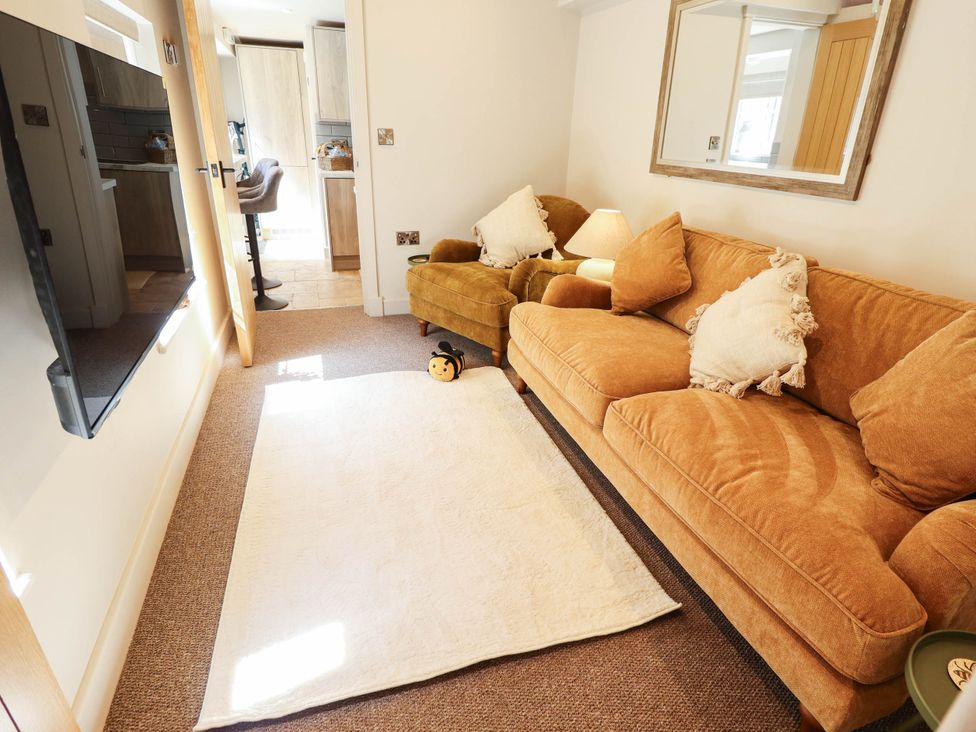 A living room with a sofa and armchair at Bee Hive Hut in Middleton, Norfolk