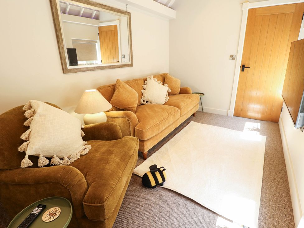 A living room with sofa and lamp at Bee Hive Hut Middleton, Norfolk