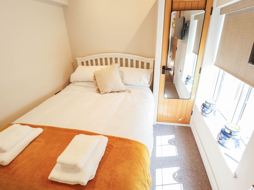 A bedroom with a bed and decorative items at Bee Hive Hut in Middleton, Norfolk