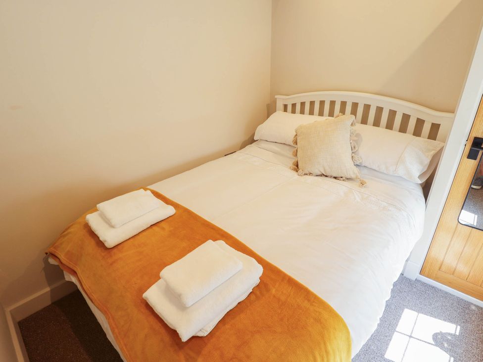 A bedroom with a bed and towels at Bee Hive Hut Middleton, Norfolk