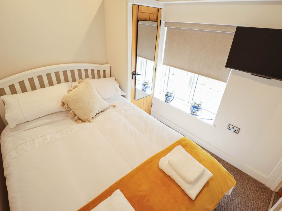 A bedroom with a bed and television at Bee Hive Hut in Middleton, Norfolk