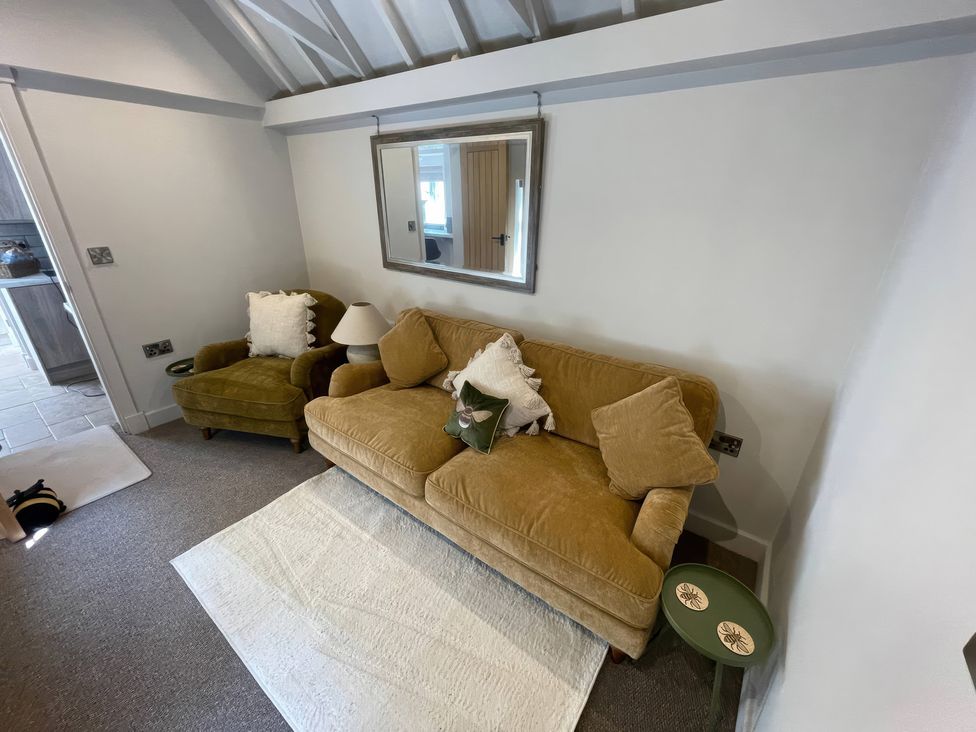 A living room with a sofa and armchair at Bee Hive Hut in Middleton, Norfolk