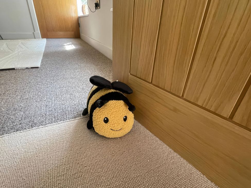 A bee plush toy next to a door at Bee Hive Hut in Middleton, Norfolk