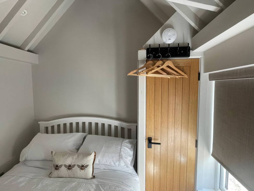 A bedroom with a bed and door at Bee Hive Hut Middleton, Norfolk