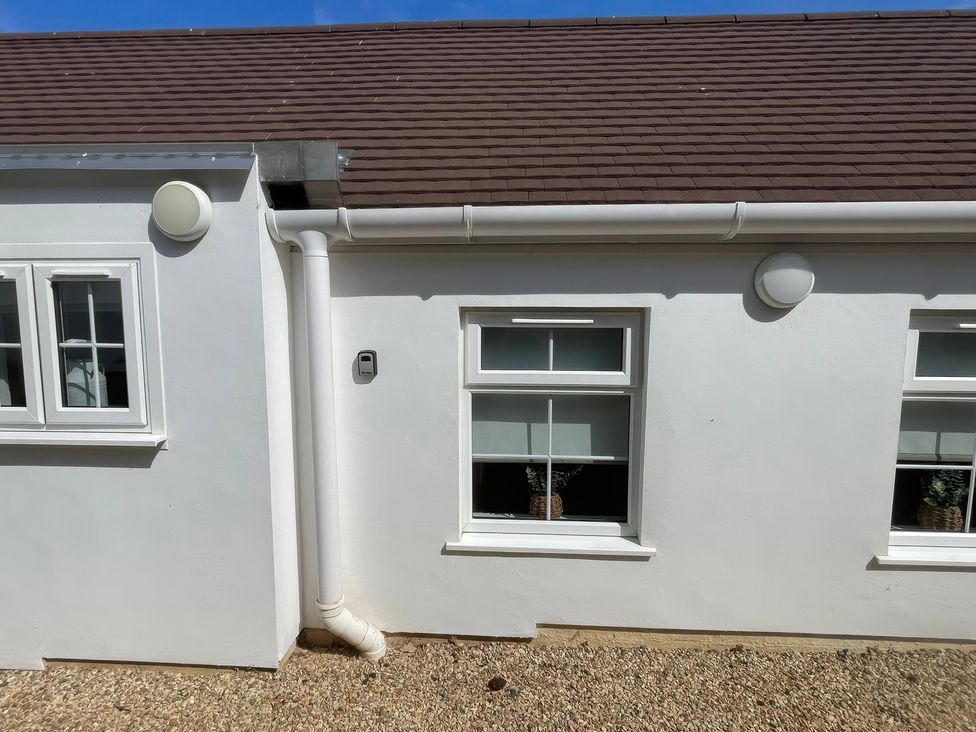 An exterior wall with windows and light fixtures at Bee Hive Hut Middleton, Norfolk