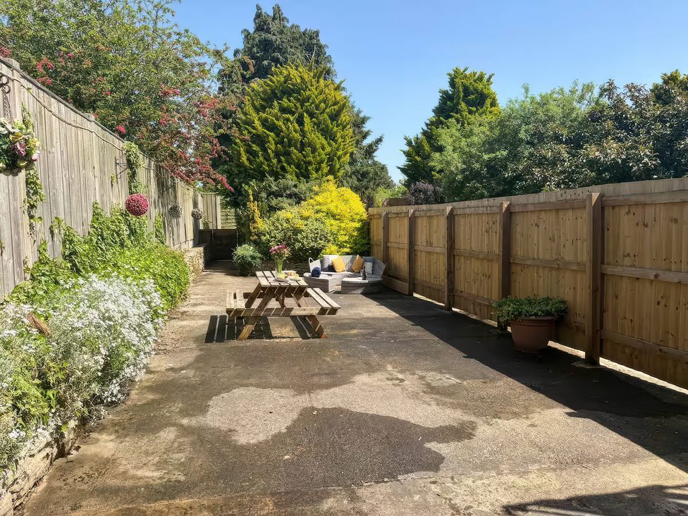 A garden with a table and benches at Owl in Pickering