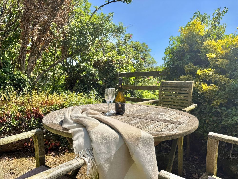 A table with a bottle and glasses in the garden at Owl in Pickering