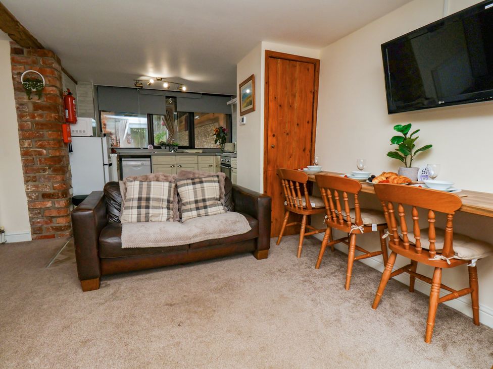 A living room with a sofa and dining area at Owl in Pickering