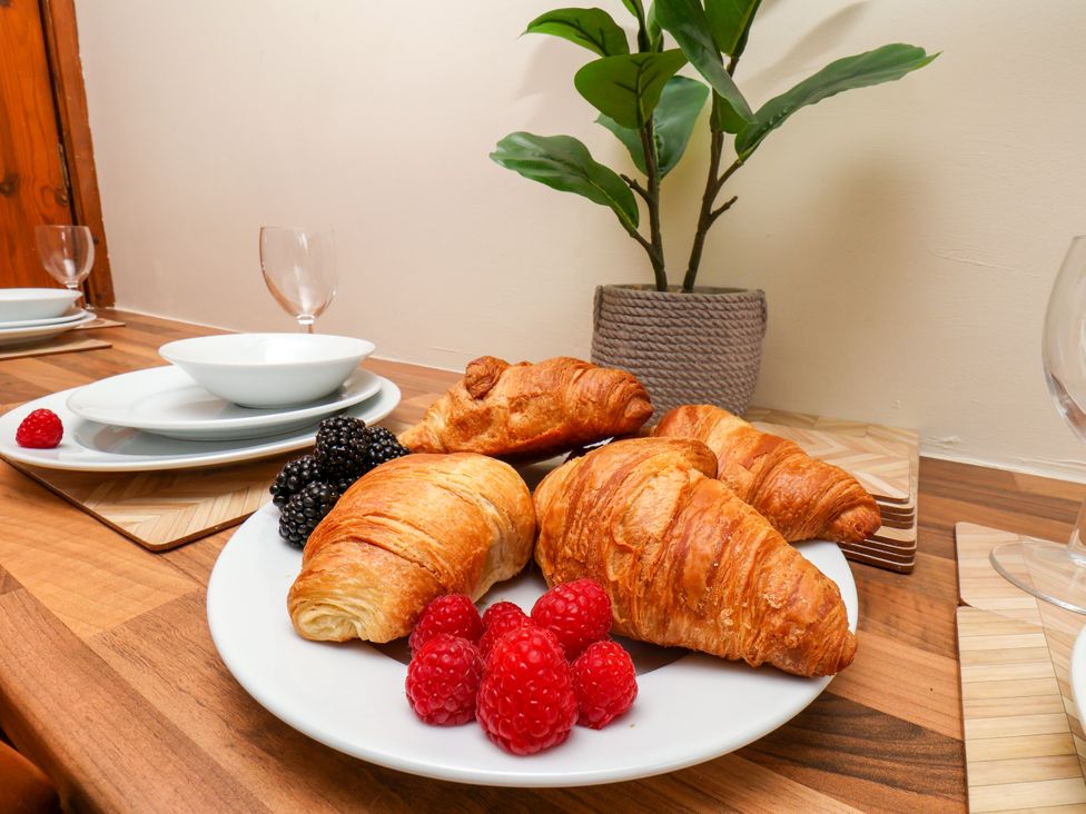 A dining table with croissants and berries at Owl in Pickering