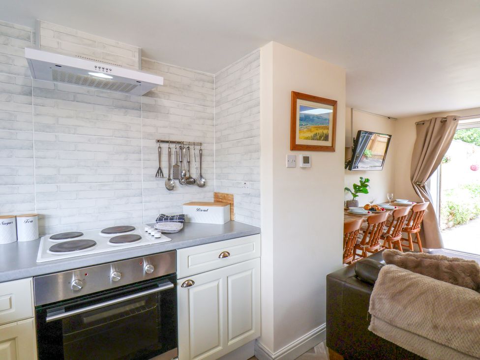 A kitchen with a stove and dining area at Owl in Pickering