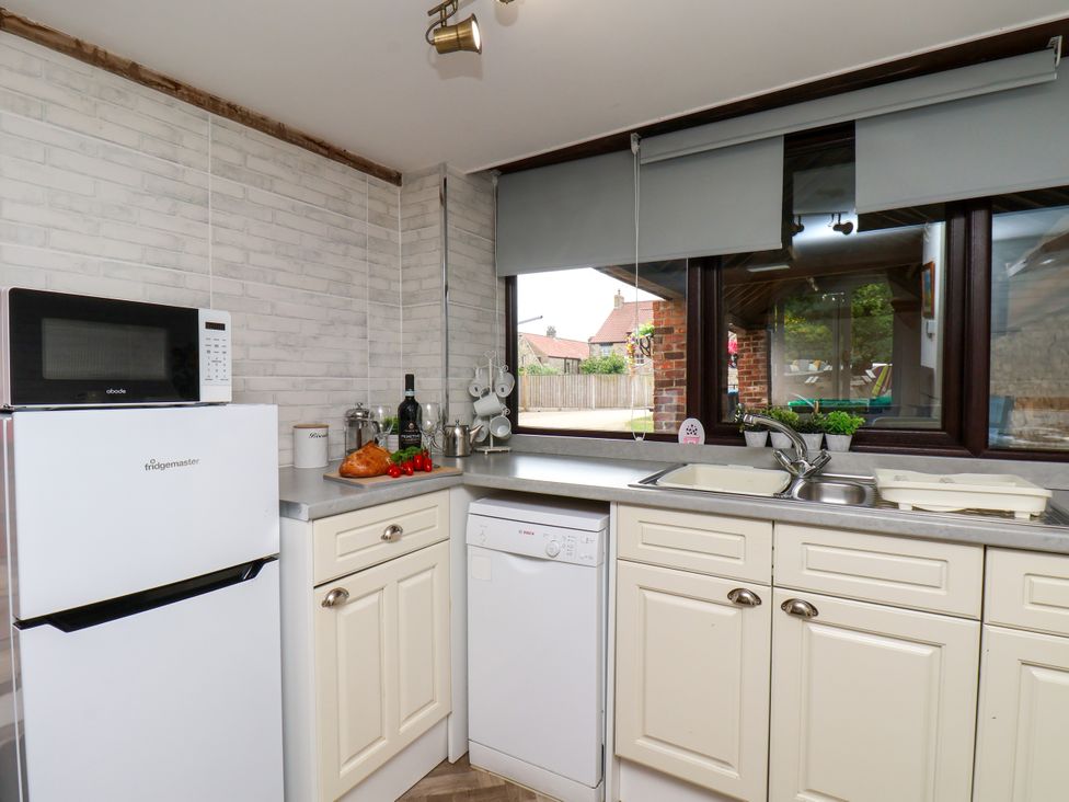 A kitchen with a refrigerator and sink at Owl in Pickering