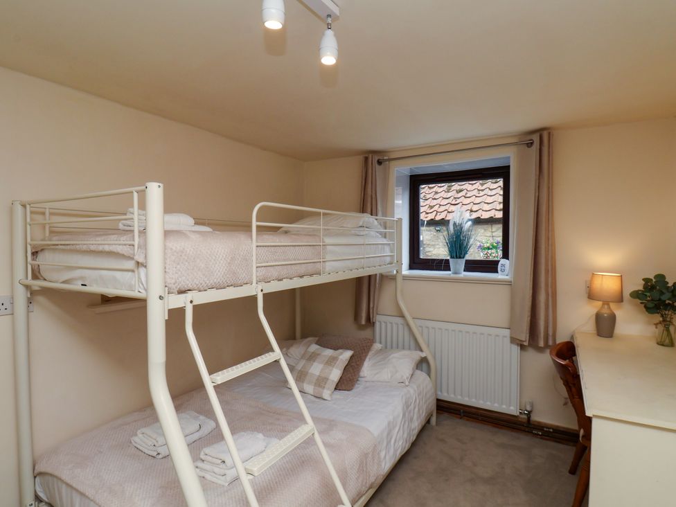 A bedroom with a bunk bed and a single bed at Owl in Pickering