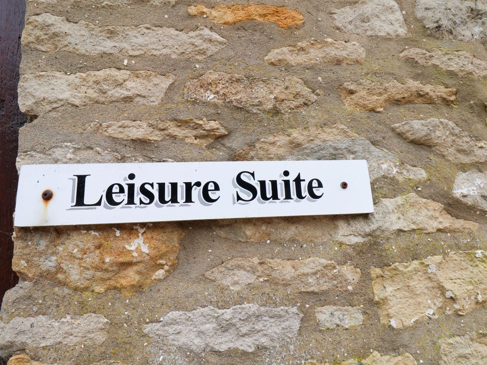 A sign reading Leisure Suite on a stone wall at Owl in Pickering