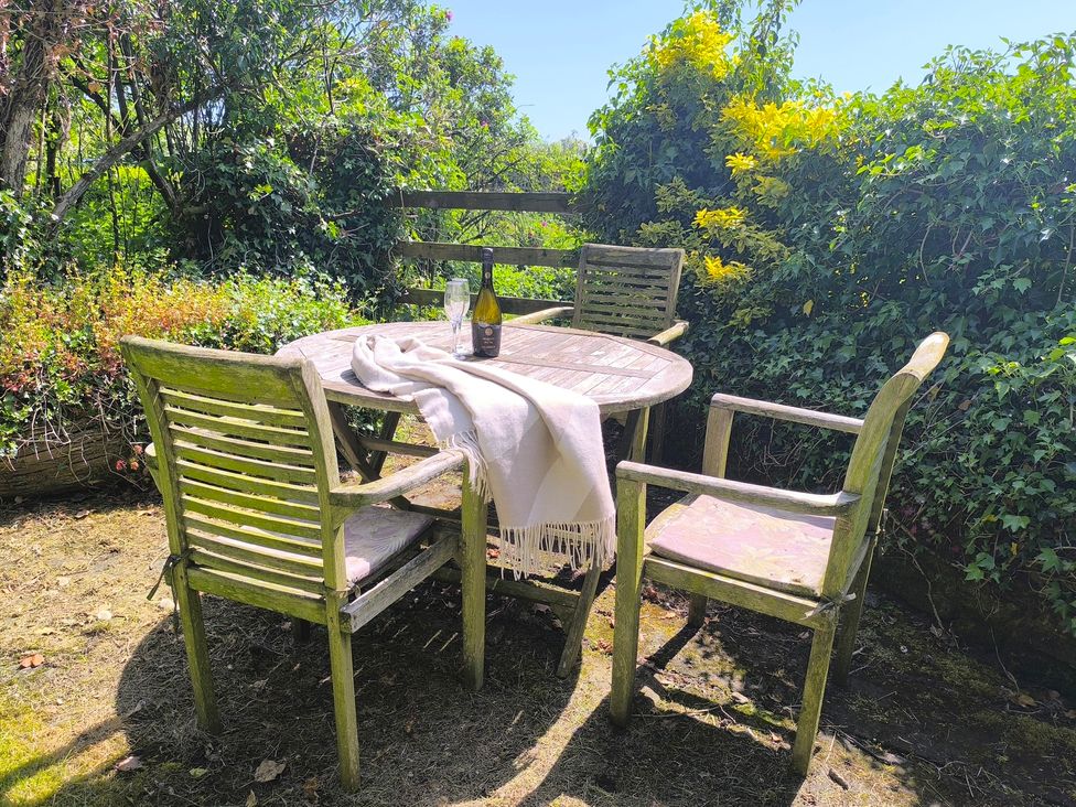 A table with chairs and a blanket in a garden at Owl in Pickering