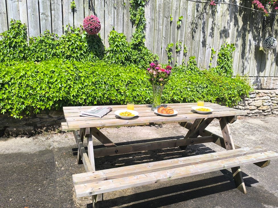 An outdoor dining area with a picnic table and plates at Owl in Pickering