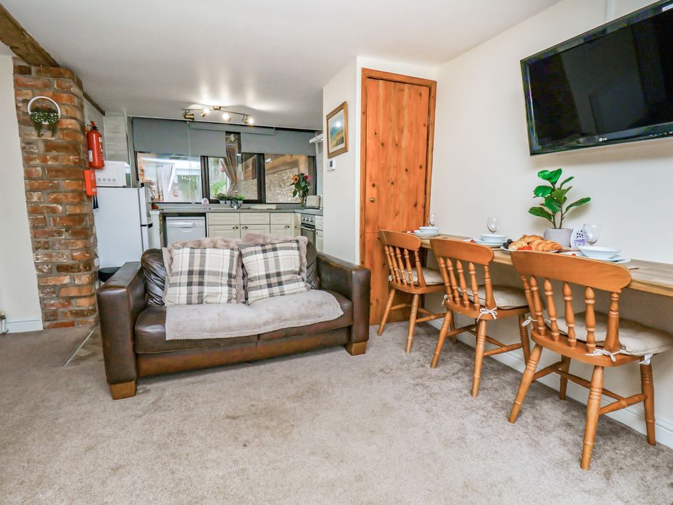 A dining room with a sofa and dining table at Owl in Pickering