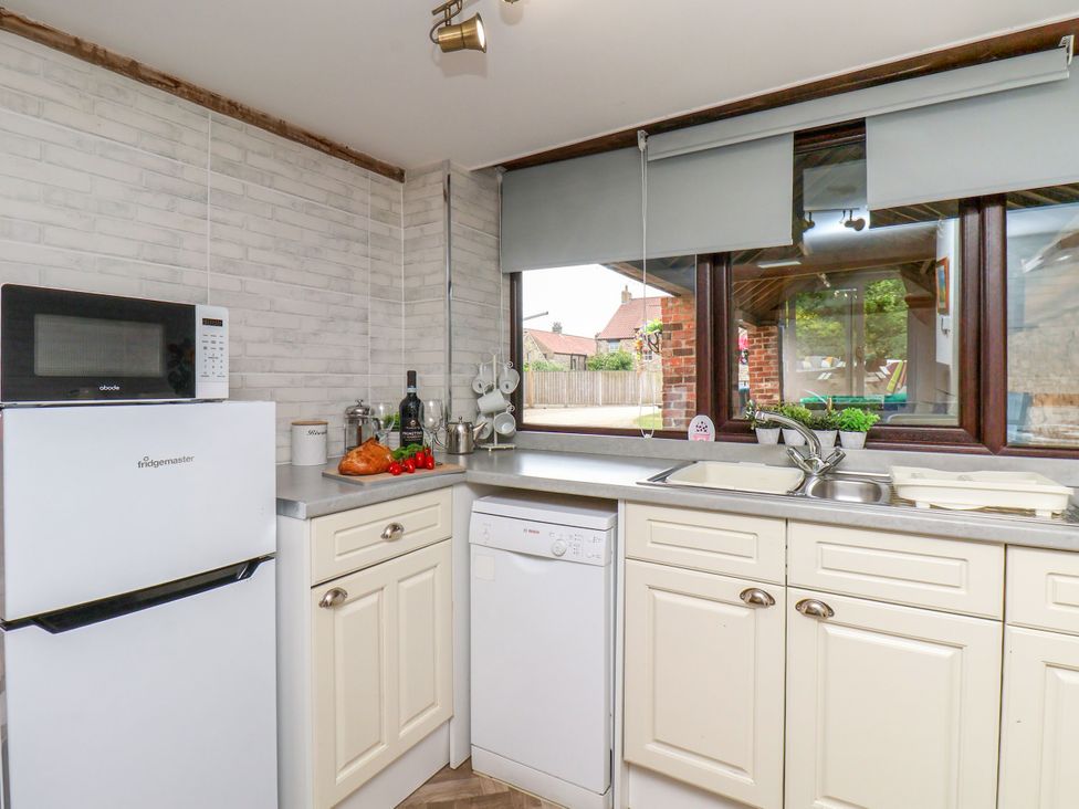 A kitchen with appliances and window view at Owl in Pickering