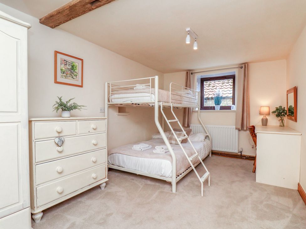 A bedroom with a bunk bed and single bed at Owl in Pickering
