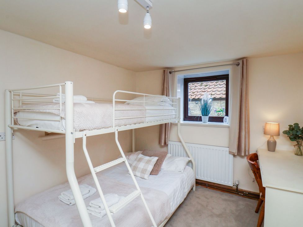 A bedroom with a bunk bed and desk at Owl in Pickering