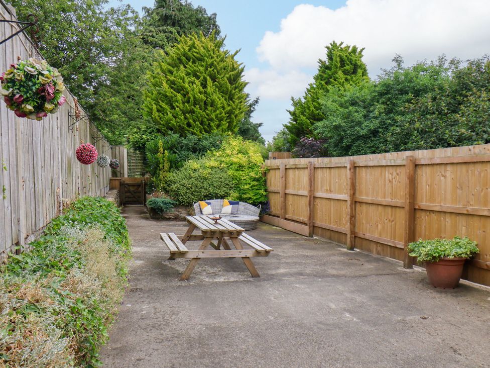 A garden with a table and benches at Owl in Pickering