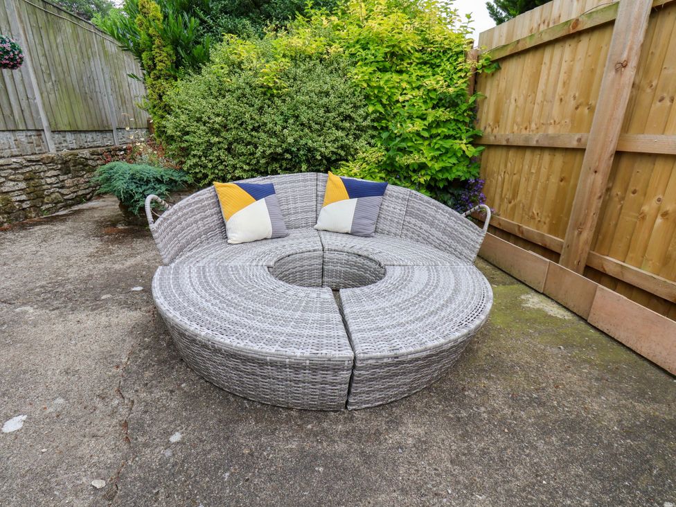 An outdoor area with a circular sofa and pillows at Owl in Pickering