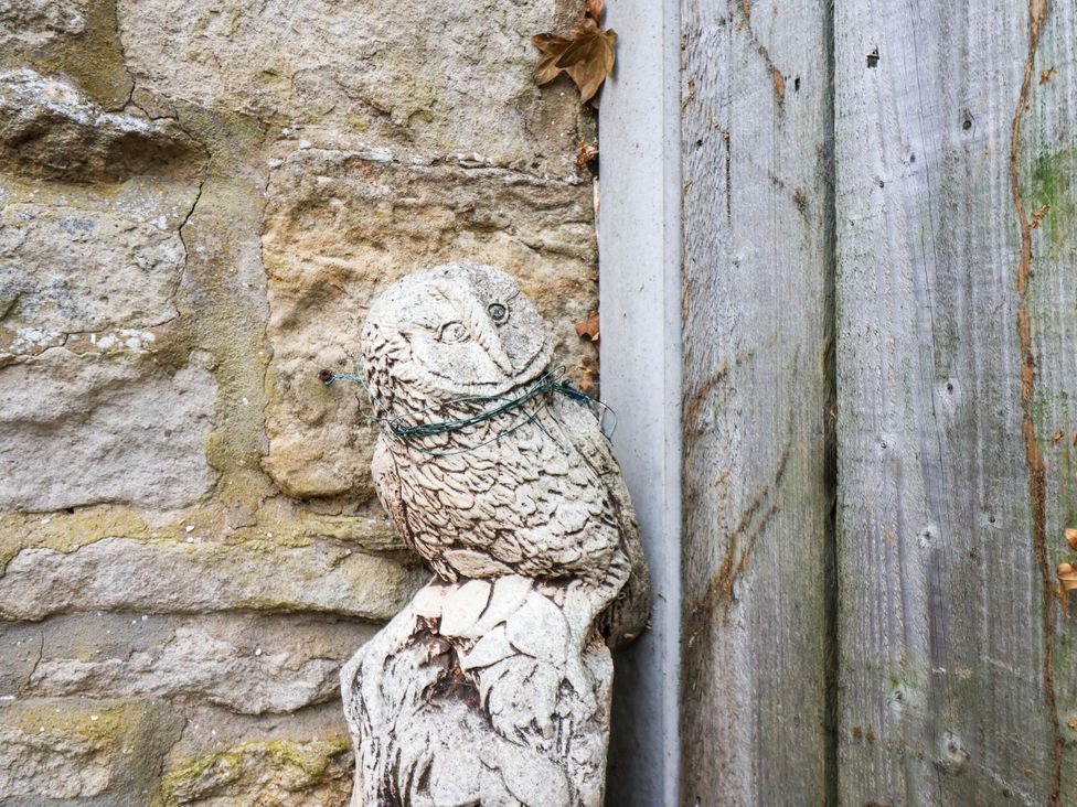 An owl statue on a stone wall at Owl in Pickering