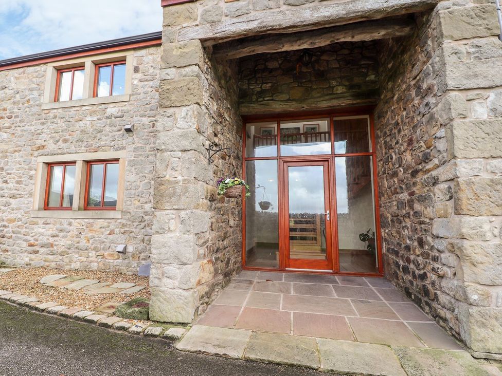 An entryway with a wooden door and stone wall at Shepherd's Barn Lancaster