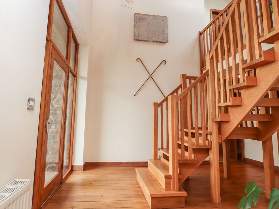 An entrance hall with a staircase and door at Shepherd's Barn in Lancaster