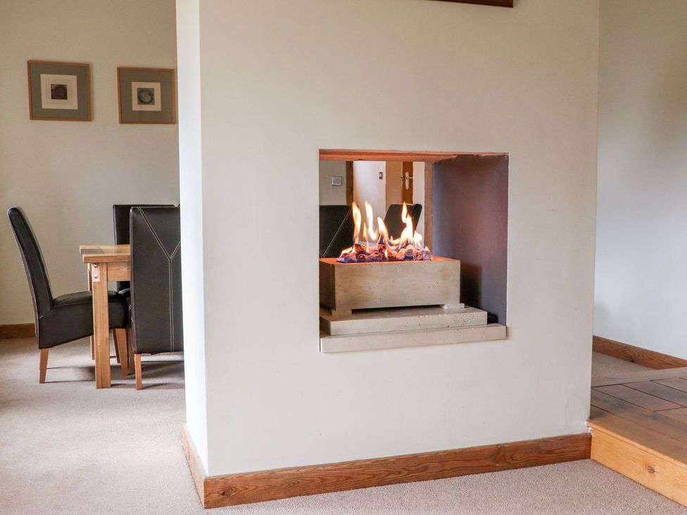 A dining room with a fireplace and dining table at Shepherd's Barn in Lancaster