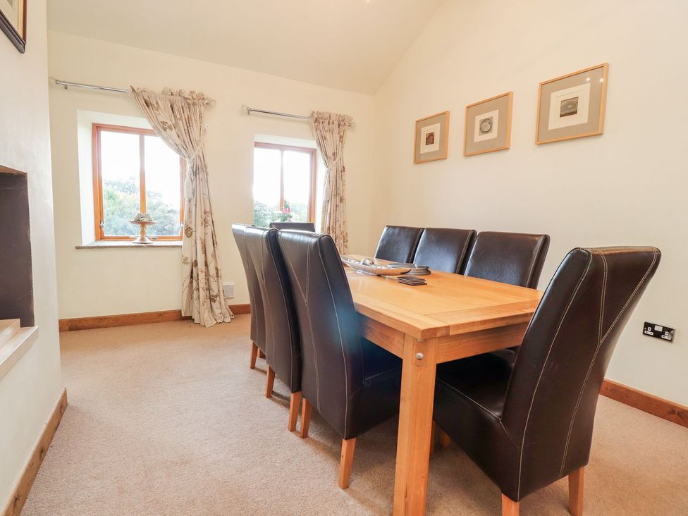 A dining room with a wooden table and chairs at Shepherd's Barn Lancaster