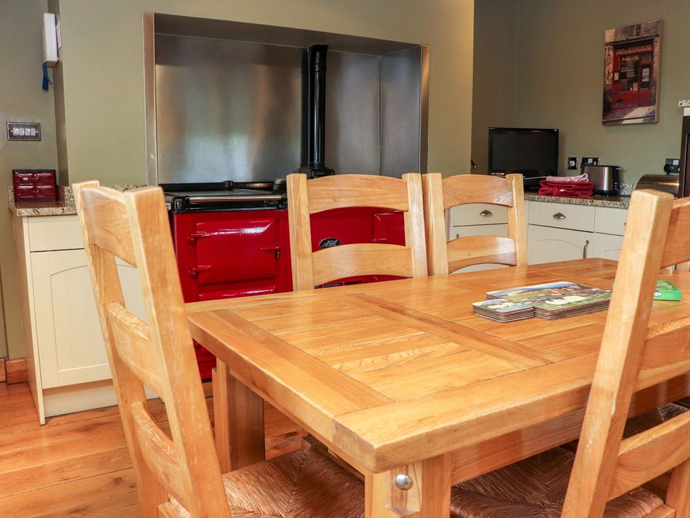 A kitchen with a table and chairs and a red stove at Shepherd's Barn in Lancaster