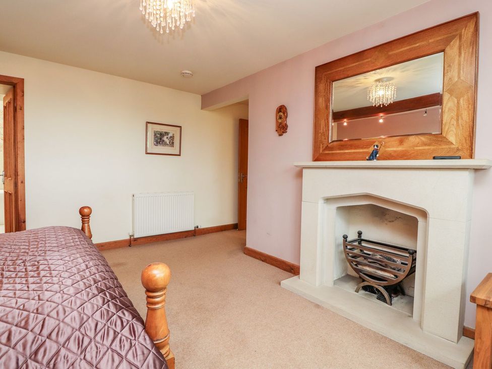 A bedroom with a bed and a fireplace at Shepherd's Barn in Lancaster