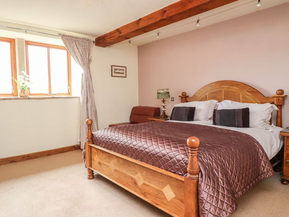 A bedroom with a bed and windows at Shepherd's Barn in Lancaster